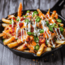 Loaded Fries topped with melted cheese, crispy bacon, and green onions.