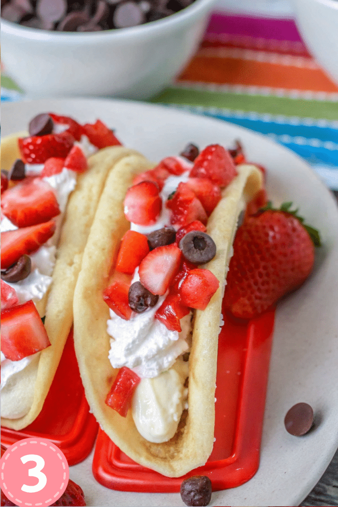 Strawberry and chocolate chip pancakes filled with cheesecake mousse, served in a red taco holder